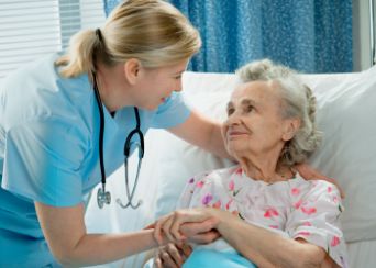 Nurse helping patient in bed